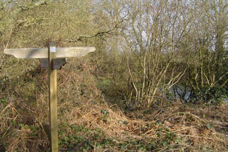 Post at crossroads of byways with Rushmoor Pond behind