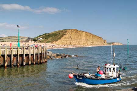 Fishing boat returning to West Bay harbour Dorset