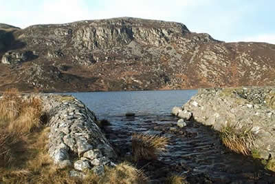 Llyn Arenig Fawr is surrounded by crags of Arenig Fawr