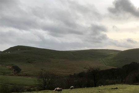 A foreboding wintry perspective of Wetton Hill.